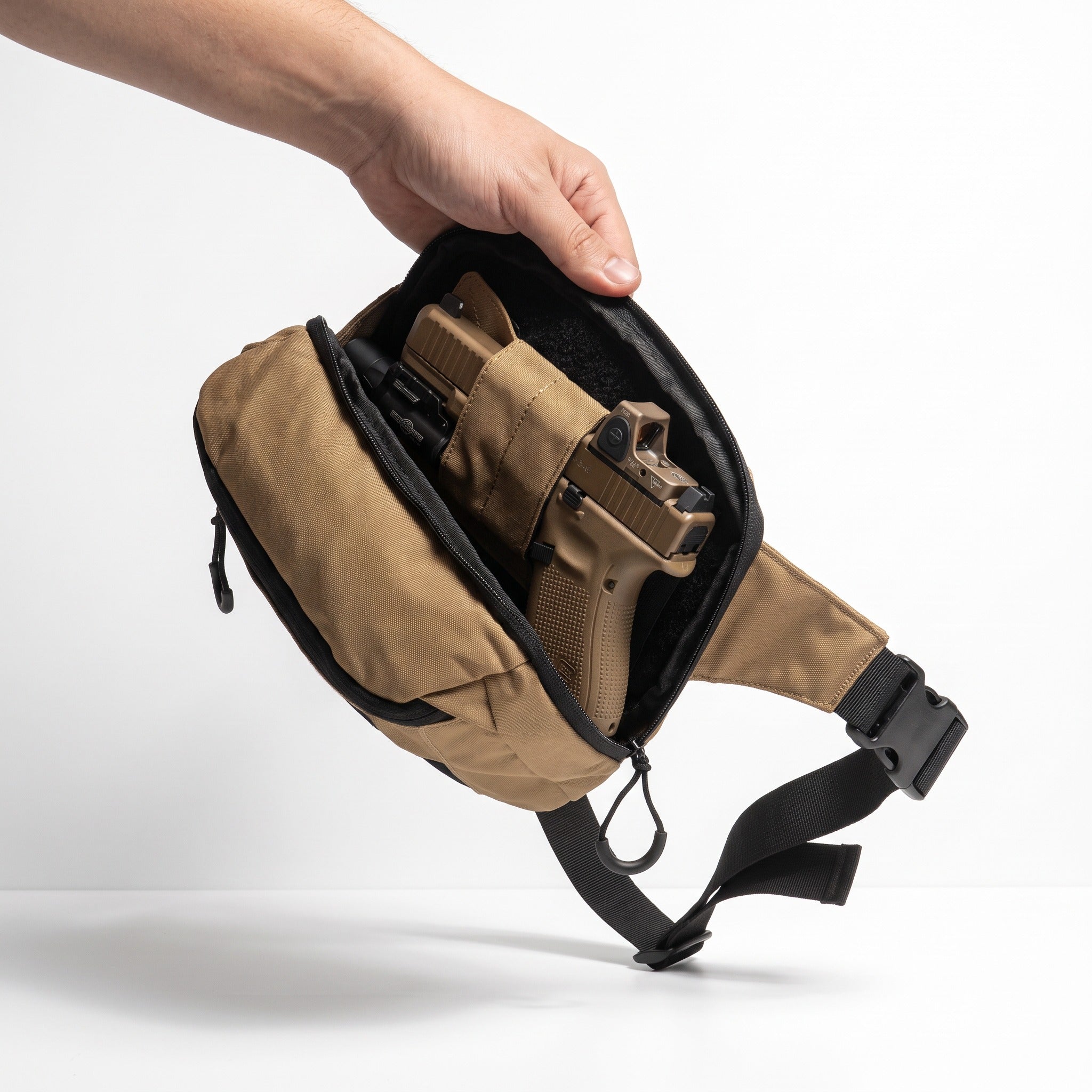 Open rear compartment of the Desert Tan ARMOTECH EDC Bag with a separately carried holstered firearm